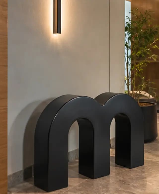 A quiet Mythos hallway detail with black sculptural seating
